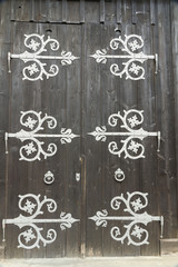 Barn doors with large decorative hinges.