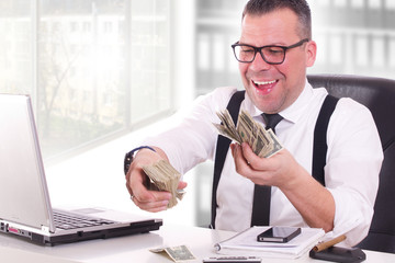 glücklicher Geschäftsmann beim Geld zählen