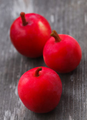 Fresh harvest of ripe red apples on a wooden surface.
