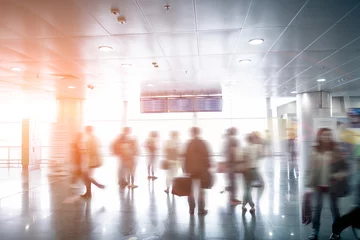 Tuinposter Luchthaven wazig passagiers kijken naar luchthavenschema op zonnige dag