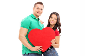 Young couple holding a red heart