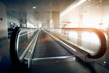 Deurstickers Luchthaven horizontale roltrap bij moderne luchthaventerminal bij zonlicht