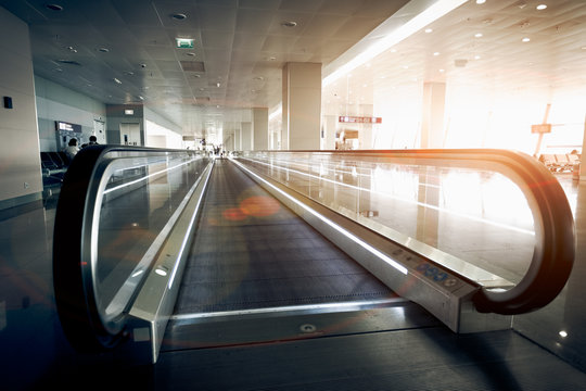 horizontal escalator at modern airport terminal at sun light