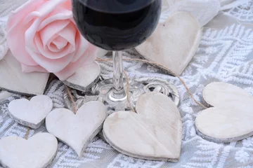 Fototapeten houten hart decoratie met roze roos en deel van glas wijn © trinetuzun