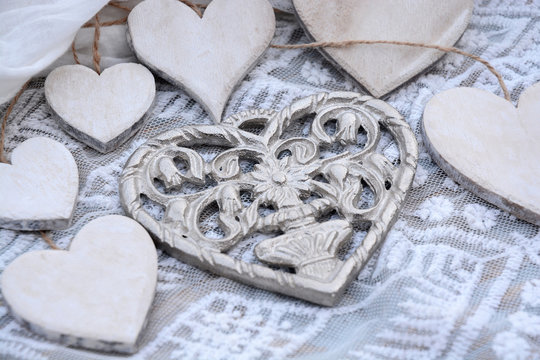 metalen hart met houten hartjes op transparante stof