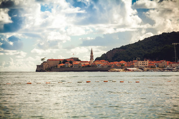 ancient city with red roofs and defense tower on sea coat