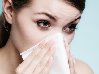 Flu allergy. Sick girl sneezing in tissue. Health