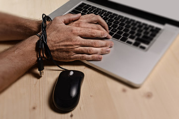 man work slave bond to computer laptop internet addict
