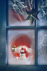 Frosted window with Christmas decorations inside