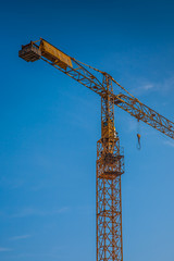 Fototapeta premium yellow construction crane on building site