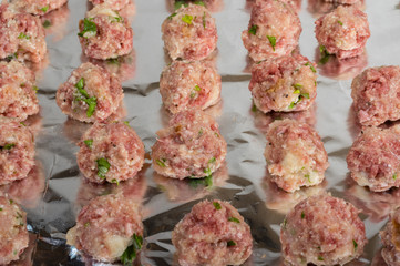 Tray of raw meatballs ready to bake