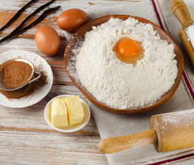 Eggs, flour, sugar, butter on  white  a white wooden table