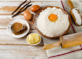 Eggs, flour, sugar, butter on  white  wooden table