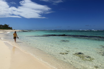 Fototapeta na wymiar femme en promenade sur plage de l'île maurice