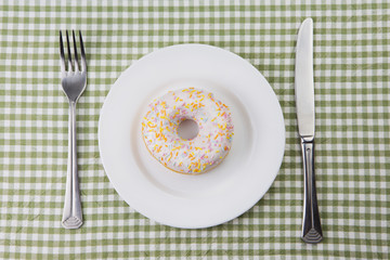 Plate with donut with multicolored glaze.
