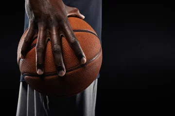 Fotobehang Hand of basketball player holding a ball © Jacob Lund