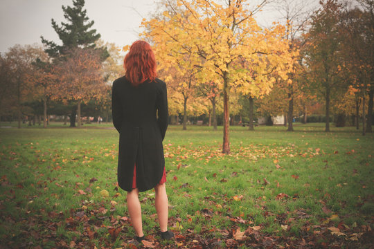 Woman standing by tree in autumn