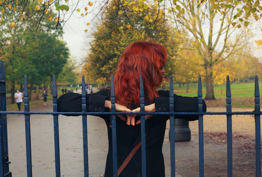 Woman leaning on gate in park