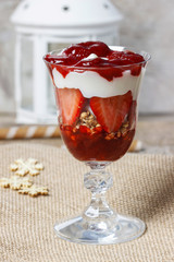 Layer strawberry and muesli dessert in glass goblet