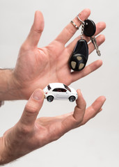 Man holding keys and small car