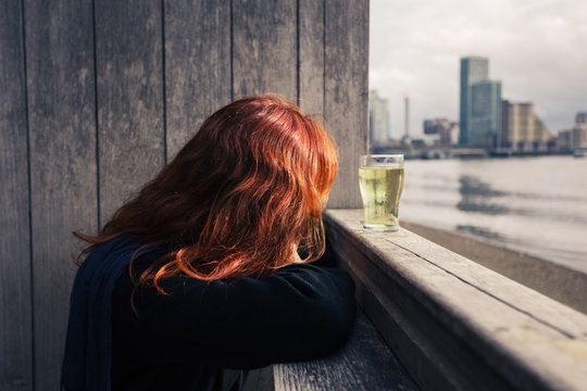 Woman drinking beer by the river