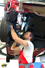 Automechaniker kontrolliert Reifen, Bremsen und Federung