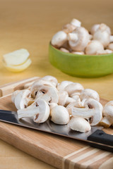 White mushrooms chopped on a wooden board