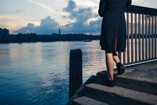 Woman stranding on stairs by river