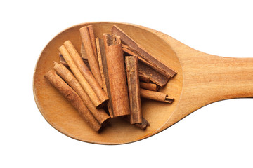 Wooden spoon with cinnamon isolated