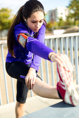 Young woman stretching and preparing for running