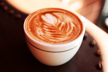 Cup of coffee with cute drawing in cafe