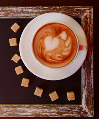 Cup of coffee with cute drawing in cafe