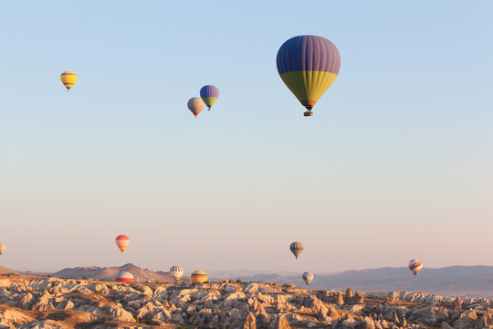 Multicolored balloons in flying in sky, sunrise time