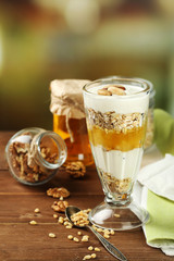 Tasty dessert with oat flakes and honey, on table