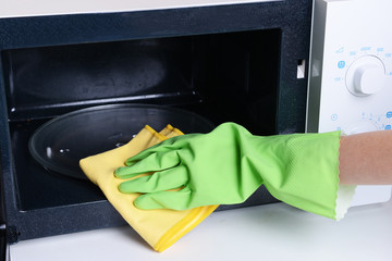 Cleaning microwave oven in kitchen close-up