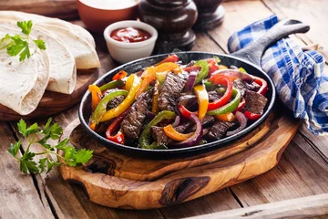 Abwaschbare Fototapete Beef Fajitas with colorful bell peppers in pan and tortilla brea © Natalia Lisovskaya