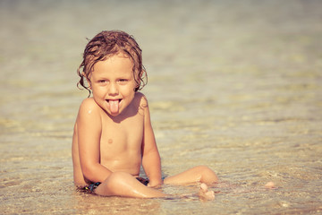 Fototapeta na wymiar little boy sitting on the beach