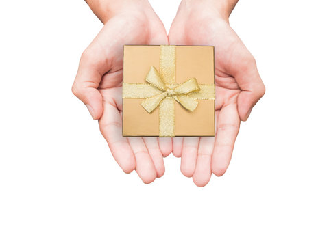 Hand holding golden gift box isolated