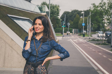 Pretty girl talking on phone in the city streets