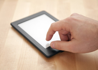 Tablet or e-book reader on wood background