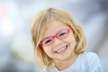 Cute blond little girl with pink eyeglasses © goodluz