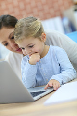 Fototapeta na wymiar Mother and little girl using laptop computer