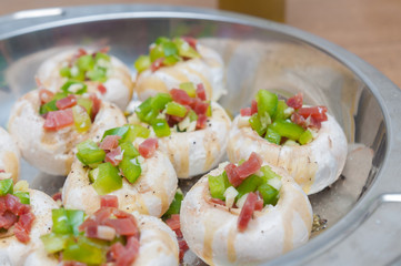 Preparing mushrooms stuffed with ham and pepper