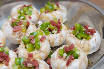 Preparing mushrooms stuffed with ham and pepper