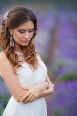 Fototapeta premium Beautiful bride in wedding dress in lavender field