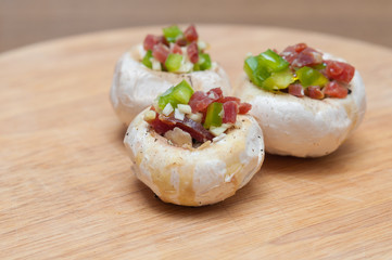 Preparing mushrooms stuffed with ham and pepper