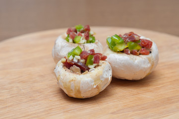 Preparing mushrooms stuffed with ham and pepper