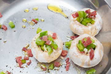 Preparing mushrooms stuffed with ham and pepper