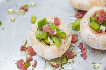 Preparing mushrooms stuffed with ham and pepper