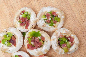 Preparing mushrooms stuffed with ham and pepper
